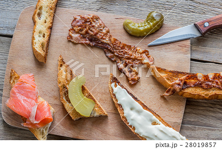 Toasts with different toppings on the wooden board Toasts with different toppings on the wooden board 28019857