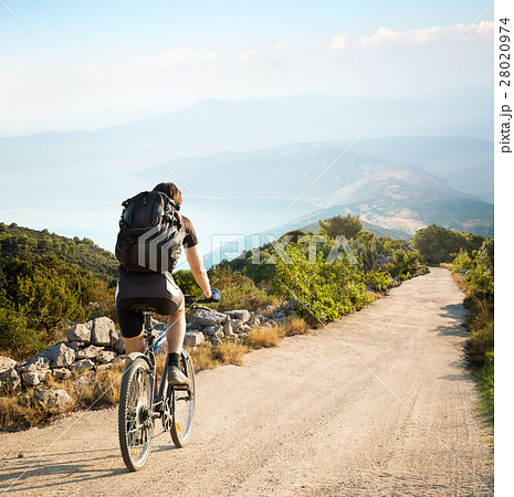 Man with Backpack Riding a Bicycle in Mountains 28020974