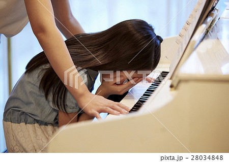 ピアノがうまく弾けない女の子の写真素材