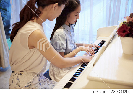 ピアノレッスンを受ける女の子の写真素材