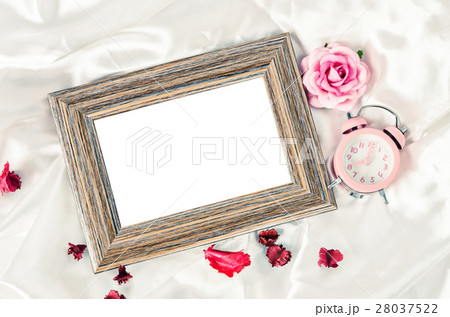 Blank wooden photo frame and pink alarm clock. Blank wooden photo frame and pink alarm clock. 28037522