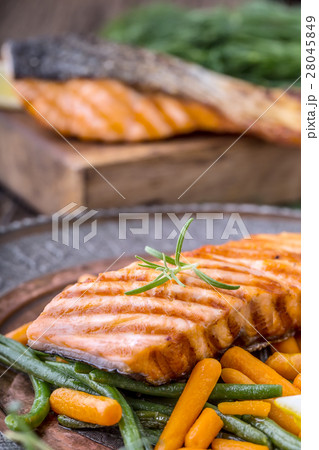 Grilled salmon, sesame seeds and herb decoration.  28045849
