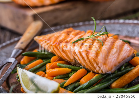 Grilled salmon, sesame seeds and herb decoration.  28045850
