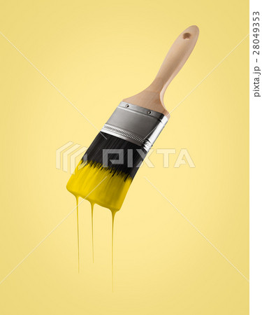 Paintbrush loaded with yellow color dripping. 28049353