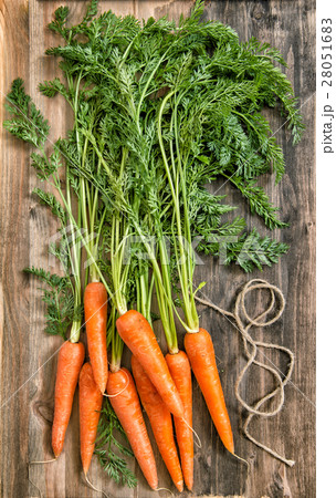 Fresh carrot roots green leaves rustic wooden back Fresh carrot roots green leaves rustic wooden back 28051683
