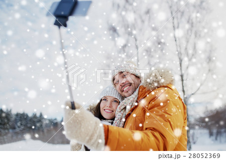 happy couple taking selfie by smartphone in winter 28052369