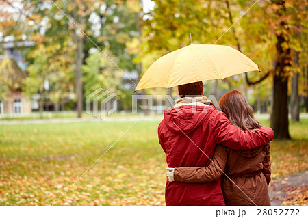 happy couple with umbrella walking in autumn park happy couple with umbrella walking in autumn park 28052772