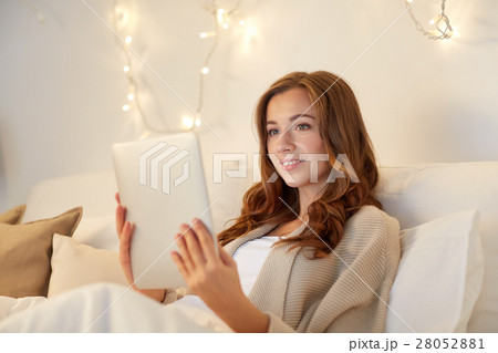happy young woman with tablet pc in bed at home 28052881