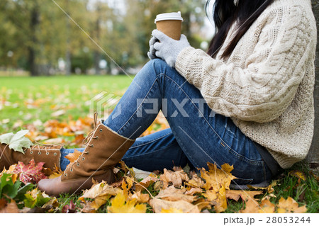 close up of woman drinking coffee in autumn park 28053244