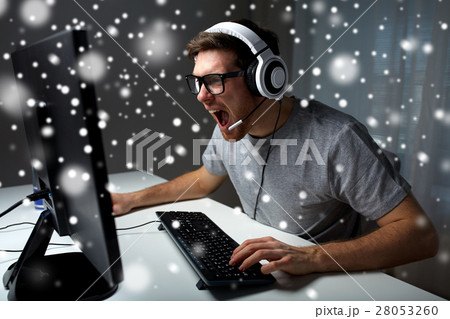 man in headset playing computer video game at home 28053260