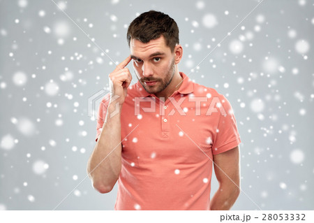 man with finger at temple over snow background man with finger at temple over snow background 28053332