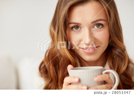 close up of happy woman with coffee cup at home 28053347