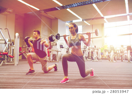 young man and woman training with barbell in gym young man and woman training with barbell in gym 28053947