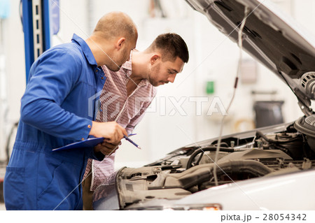 auto mechanic with clipboard and man at car shop 28054342