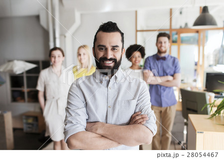 happy young man over creative team in office happy young man over creative team in office 28054467
