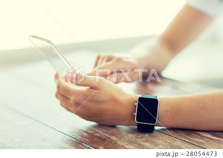 close up of hands with smart phone and watch 28054473