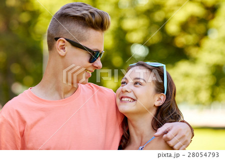 happy teenage couple looking at each other in park 28054793