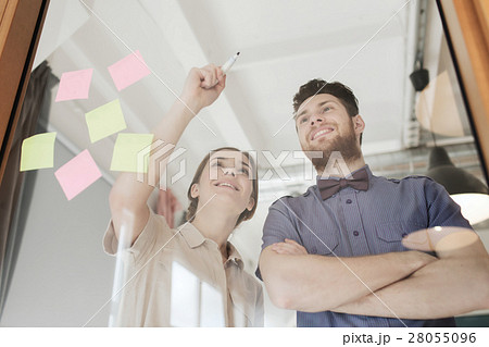 happy creative team writing on blank office glass happy creative team writing on blank office glass 28055096