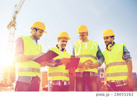 group of smiling builders with tablet pc outdoors group of smiling builders with tablet pc outdoors 28055262