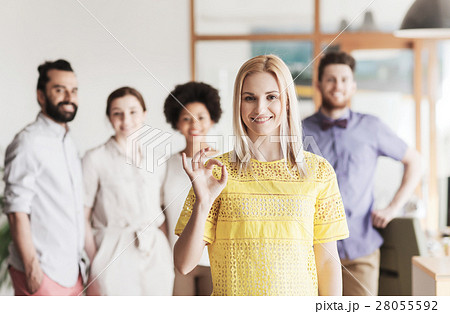 happy woman showing ok over creative office team happy woman showing ok over creative office team 28055592