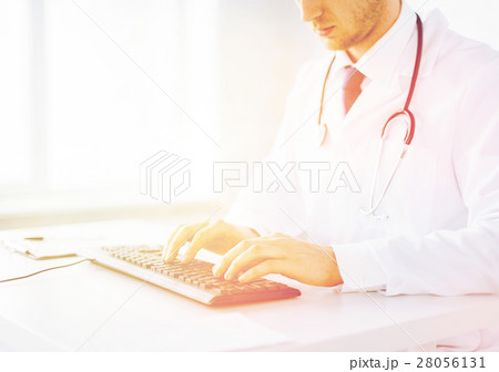 male doctor typing on the keyboard 28056131