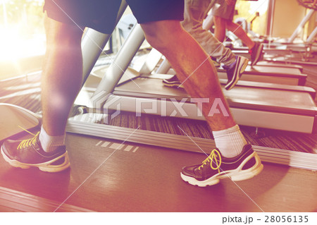 close up of men legs walking on treadmills in gym close up of men legs walking on treadmills in gym 28056135