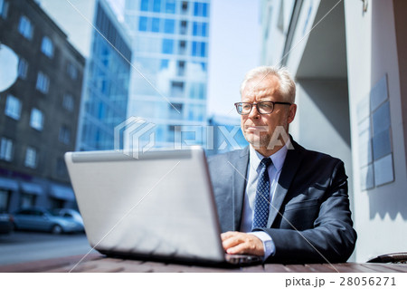 senior businessman with laptop at city street cafe senior businessman with laptop at city street cafe 28056271