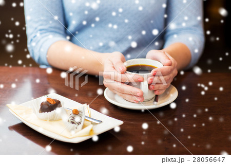 close up of woman holding coffee cup and dessert close up of woman holding coffee cup and dessert 28056647