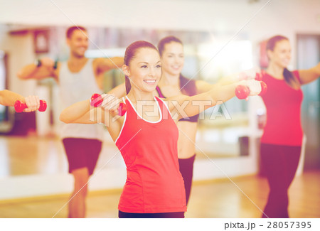 group of smiling people working out with dumbbells group of smiling people working out with dumbbells 28057395