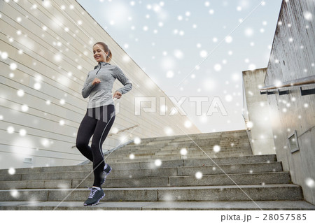 happy sporty woman running downstairs in city 28057585