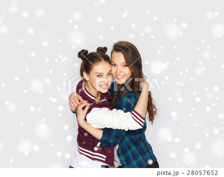 happy smiling teenage girls hugging over snow 28057652