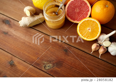 honey, citrus fruits, ginger and garlic on wood honey, citrus fruits, ginger and garlic on wood 28058182
