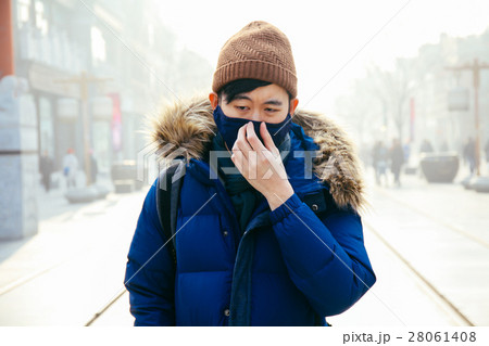 Man walking & wearing a face mask in a foggy smog Man walking & wearing a face mask in a foggy smog 28061408