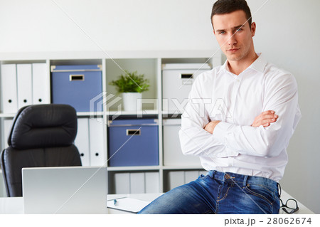 Man in a polo shirt stands leaning on railing 28062674