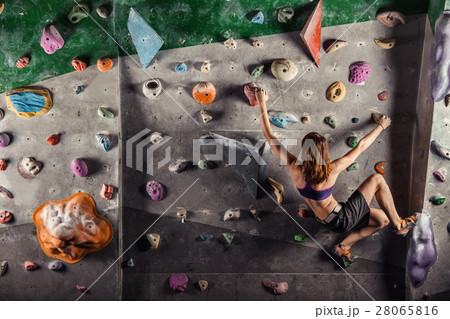 Young woman climbing up on practice wall 28065816