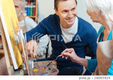 Friendly artist helping elderly woman in painting Friendly artist helping elderly woman in painting 28065924