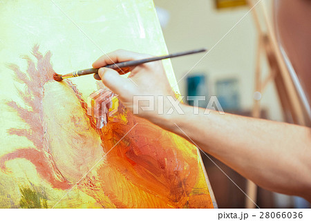 Close up of artists hand painting picture in cozy 28066036