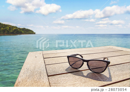 black sunglass on wood terrace at seaside 28073054