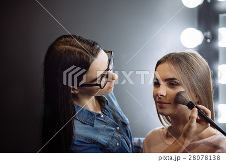 Charming attractive makeup artist using a powder Charming attractive makeup artist using a powder 28078138