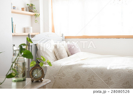 目覚まし時計と朝のベッドルームの写真素材