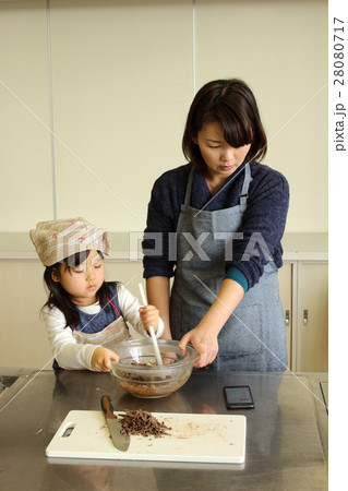 スマホを観ながらチョコレートづくりをする親子 28080717