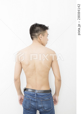 男性 後姿 背中 肉体 イメージ 全身 立つ ジーパン 白バックの写真素材