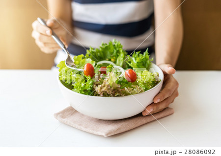 Young woman eating fresh organic vegetarian salad 28086092