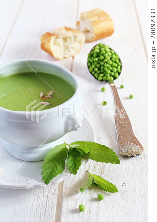 Minty Pea Soup and baguette on light background 28092331