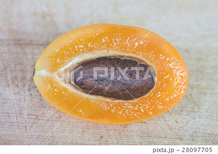 Cleaved marian plum on wooden texture background Cleaved marian plum on wooden texture background 28097705