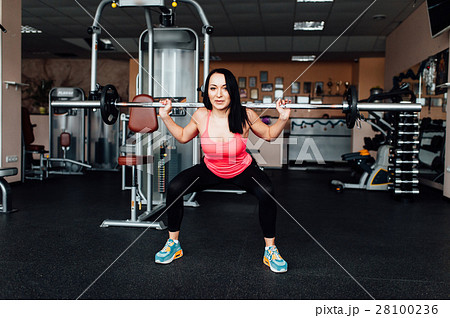 Beautiful fitness woman lifting barbell. 28100236