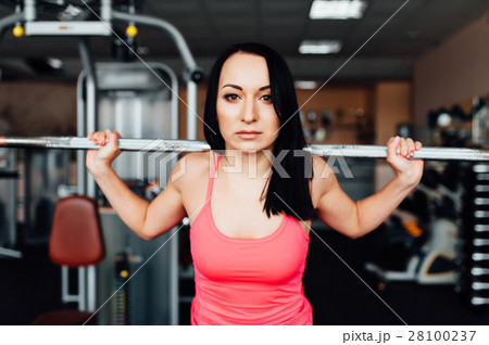 Beautiful fitness woman lifting barbell. 28100237