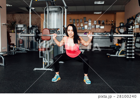 Beautiful fitness woman lifting barbell. 28100240