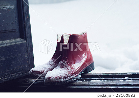 red rubber shoes covered in snow by the door red rubber shoes covered in snow by the door 28100932