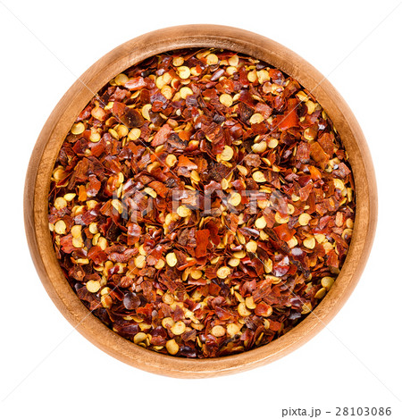 Dried chili pepper flakes in wooden bowl Dried chili pepper flakes in wooden bowl 28103086